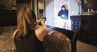 Women using gun to protect herself from intruder.